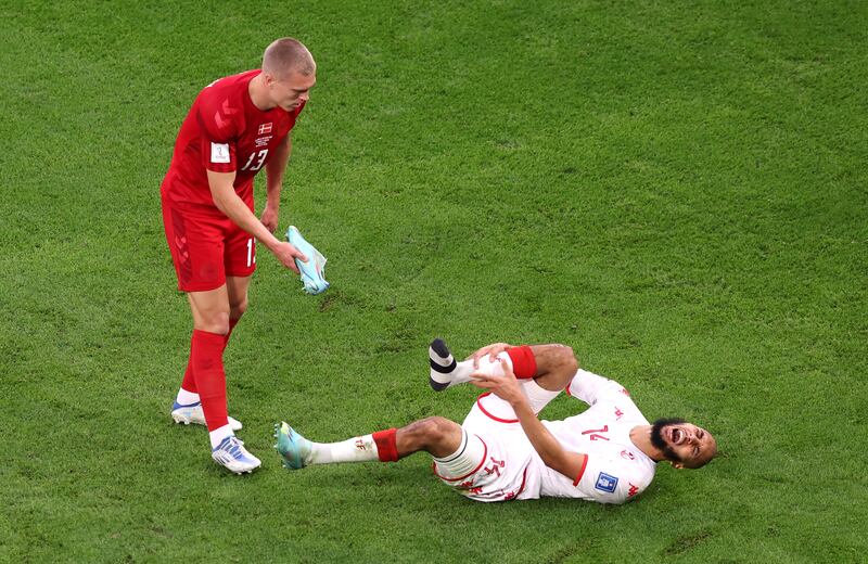 Denmark Rasmus Kristensen, left, offers Aissa Laidouni of Tunisia his boot, during their Group D match at Education City Stadium in Doha. The game ended goalless. EPA