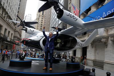 Joby Aviation founder JoeBen Bevirt poses next to the company's air taxi ahead of its listing at the New York Stock Exchange. Reuters