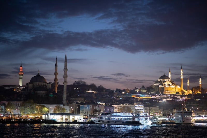 The Suleymaniye Mosque (right) and the New Mosque (left) are seen from a ferry crossing the Bosphorus in Istanbul, Turkey, during sunset.  EPA