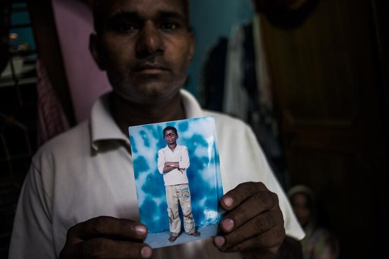 Nanak Chand holds a photo of his son, Rajan Kumar, who was killed by teenage neighbours in a fight over a kite-fighting duel on August 15. Sami Siva for The National