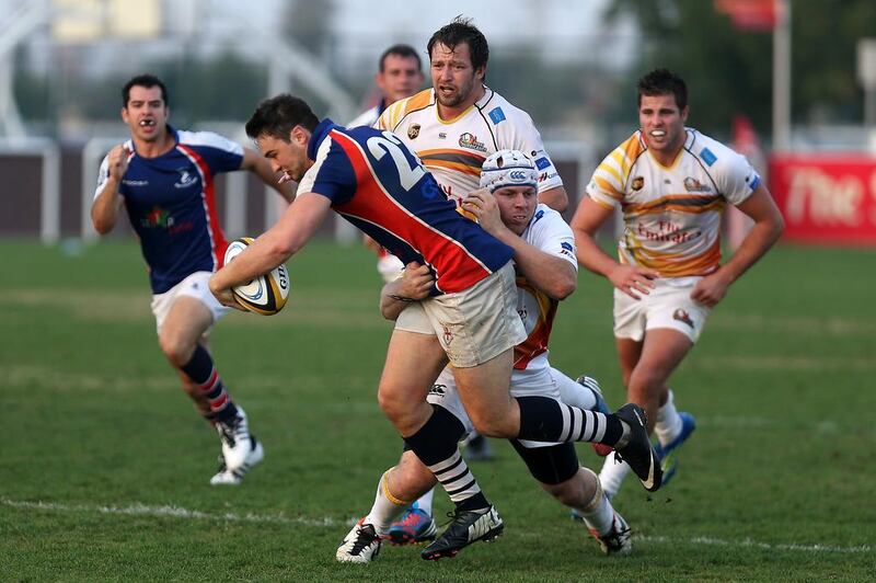 Dave Harding, second from left, helps power Jebel Ali Dragons past Dubai Hurricanes at the Sevens in Dubai on Friday. Pawan Singh / The National