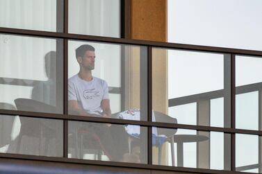 World No 1 Novak Djokovic sits on his hotel balcony in Adelaide - one of the locations where players have quarantined for two weeks upon their arrival ahead of the Australian Open. AFP