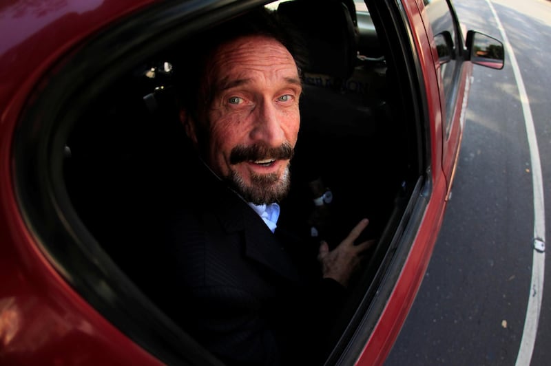 McAfee is escorted by immigration officers to the airport in Guatemala City, 2012. Reuters