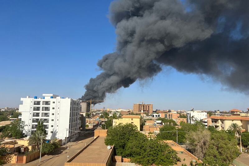 A column of smoke rises behind buildings near the airport area in Khartoum on April 19 following the collapse of a 24-hour truce. AFP