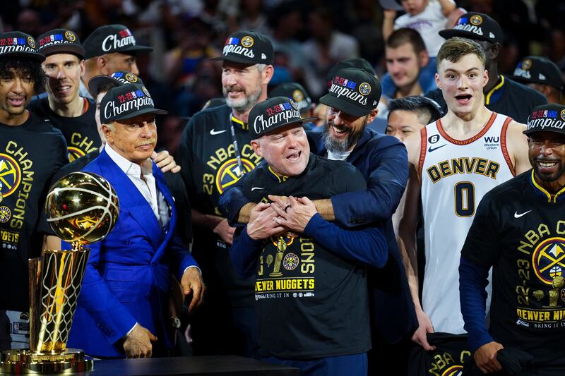 Denver Nuggets owner Josh Kroenke, centre right, hugs head coach Michael Malone after the team won the NBA Championship with a victory over the Miami Heat in Game 5 of the NBA Finals on Monday, June 12, 2023, in Denver.  AP