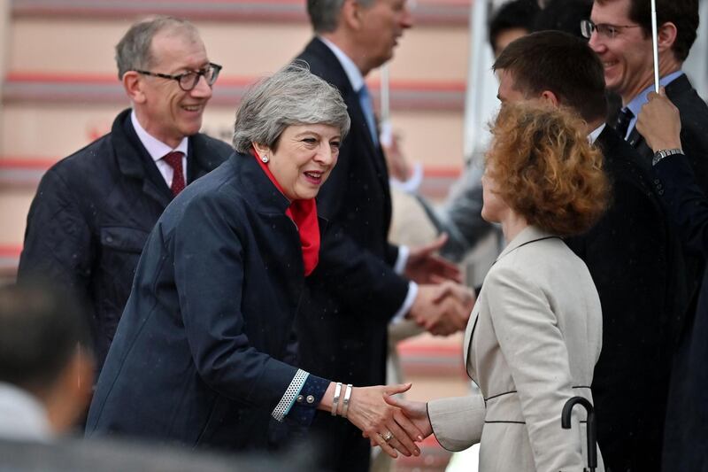 Britain's Prime Minister Theresa May and her husband Philip May are greeted as they arrive at Kansai airport in Izumisano city, Osaka prefectureahead of the G20 Osaka Summit. AFP