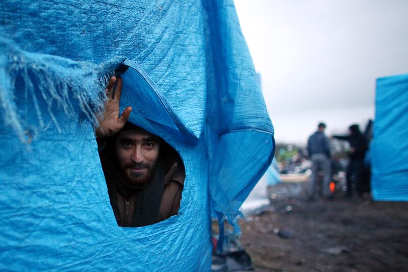 An Iranian man peers out from his shelter in the camp in January 2016