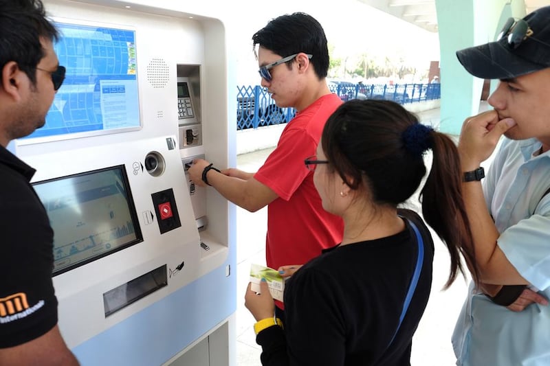 Commuter Arlean Alcampado tries out the new Hafilat fare card system for buses in Abu Dhabi at the city's main bus terminal on Friday. Delores Johnson / The National 