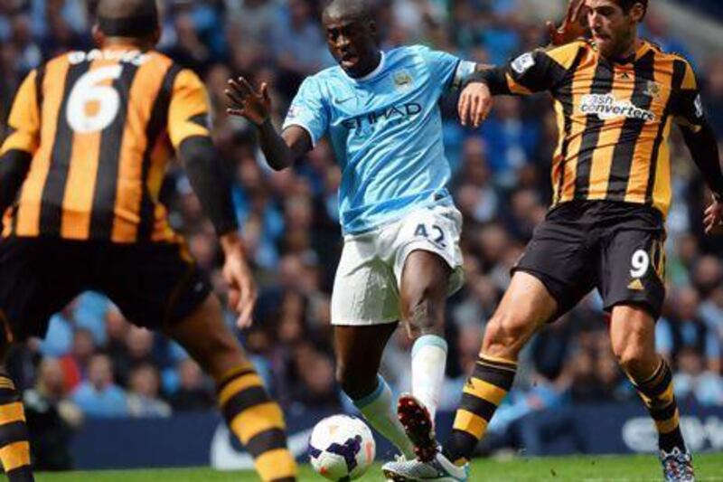 Manchester City's Yaya Toure, centre, vies with Hull City's Danny Graham, right, during their English Premier League football match at the Etihad Stadium on Saturday. Paul Ellis / AFP
