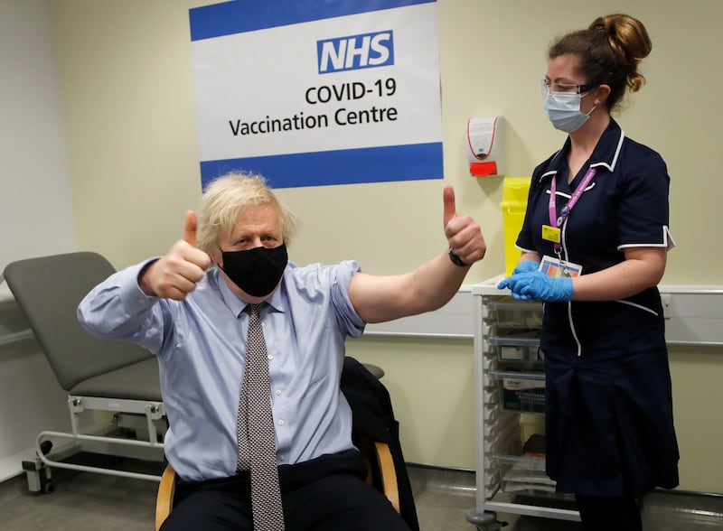 Mr Johnson gestures after receiving the first dose of AstraZeneca vaccine at St Thomas's Hospital on March 19, in London.