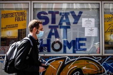 A man walks past a cinema with the words 'stay at home' on display in Berlin's Kreuzberg district. While industries such as tourism and cinema may need several quarters to recover, people will eventually return to their old habits, say analysts. AFP