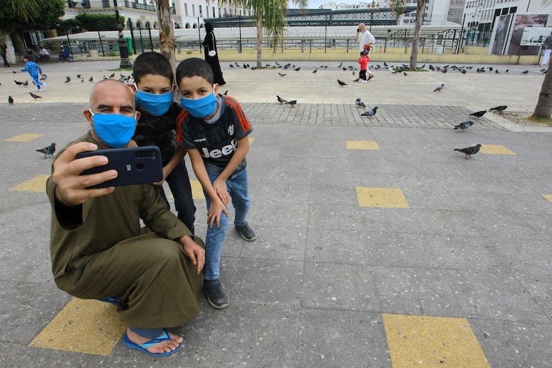 A family takes a selfie in a deserted square of Algiers. AP Photo