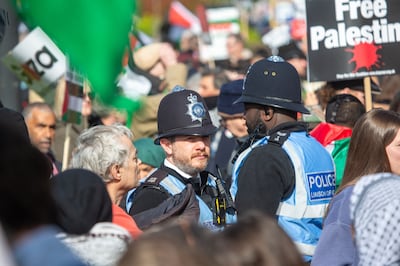 Police officers stand as pro-Palestinian protesters take part in a 'National March for Palestine' in central London. EPA