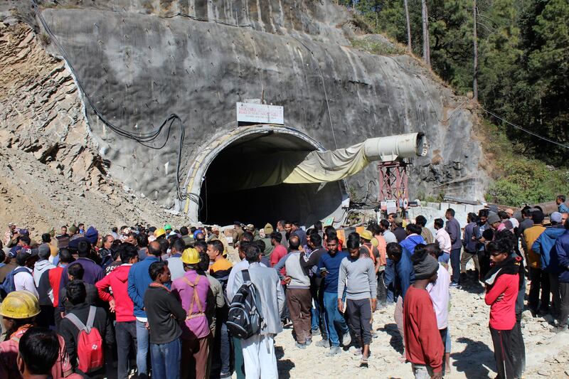 People watch rescue and relief operations at the site of the tunnel collapse. AP