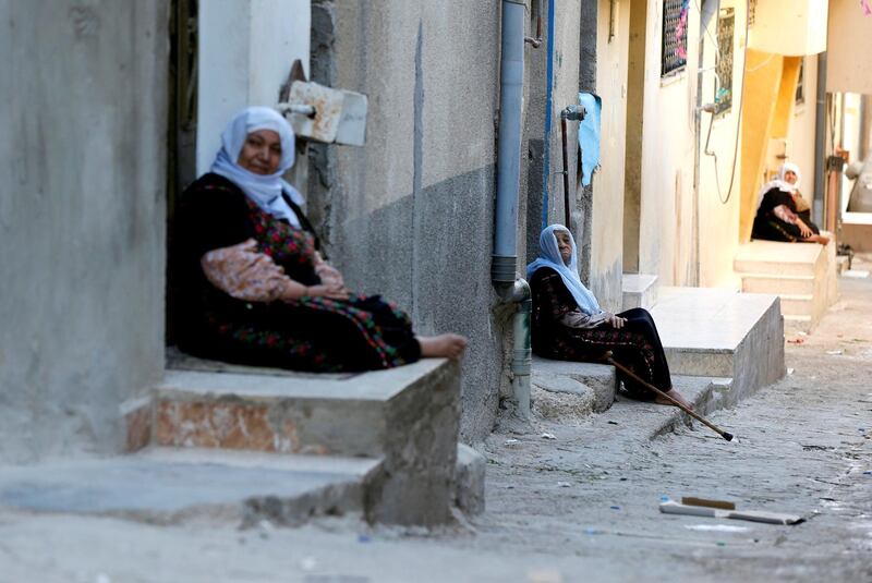 Palestinian refugee women sit if front their homes during the holy month of Ramadan, in Al-Baqaa Palestinian refugee camp, near Amman, Jordan, May 29, 2018. Reuters/Muhammad Hamed