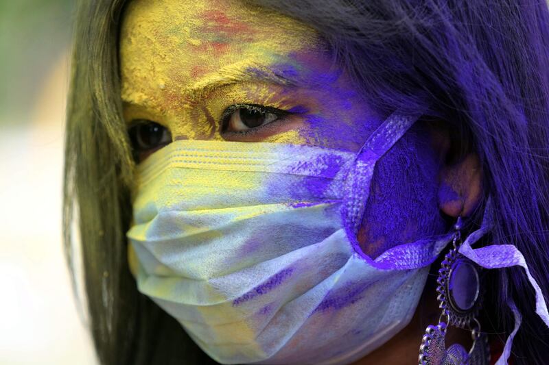 An Indian college student wearing a face mask as precautionary measure against the COVID-19 coronavirus attends Holi festival celebrations in Bhopal, India on 09 March. The Holi festival is celebrated on the full moon day and heralds the onset of spring season. EPA