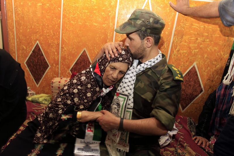 Freed Palestinian prisoner Salah al-Sahair (R), who was held by Israel for 21 years, kisses his mother on the head following his return to the family home in Khan Younis in the southern Gaza Strip, early on August 14, 2013. Israel freed 26 Palestinian prisoners on August 14, hours before the two sides were to hold new direct peace talks amid a growing row over settlements.      AFP PHOTO / SAID KHATIB
 *** Local Caption ***  734314-01-08.jpg