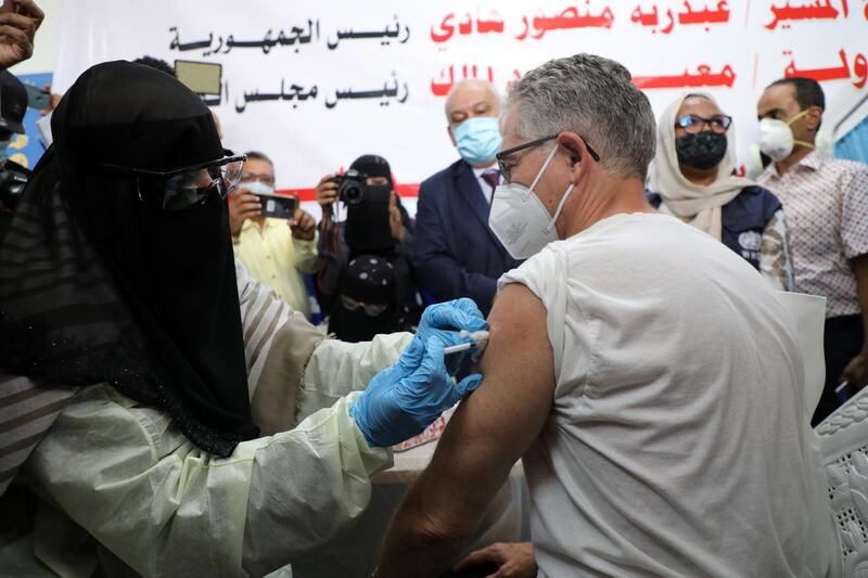 epa09147722 A man (R) receives a dose of COVID-19 vaccine in the southern port city of Aden, Yemen, 20 April 2021. Yemen's Saudi-backed government launched the COVID-19 vaccination program against the coronavirus pandemic in Aden city and the southern areas under its control, targeting more than 300,000 people.  EPA/NAJEEB ALMAHBOOBI
