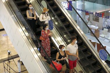 Shoppers wear face masks at Dubai's Mall of the Emirates. Contactless check-out is being expedited across the GCC due to social distancing measures. Pawan Singh / The National