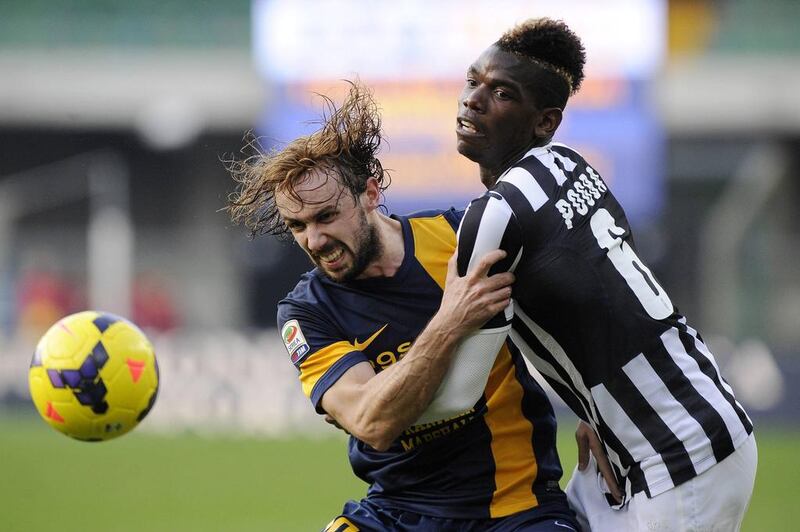 Juventus' Paul Pogba, right, fights for an aerial ball with Hellas Verona's Marco Donadel. Giorgio Perottino / Reuters