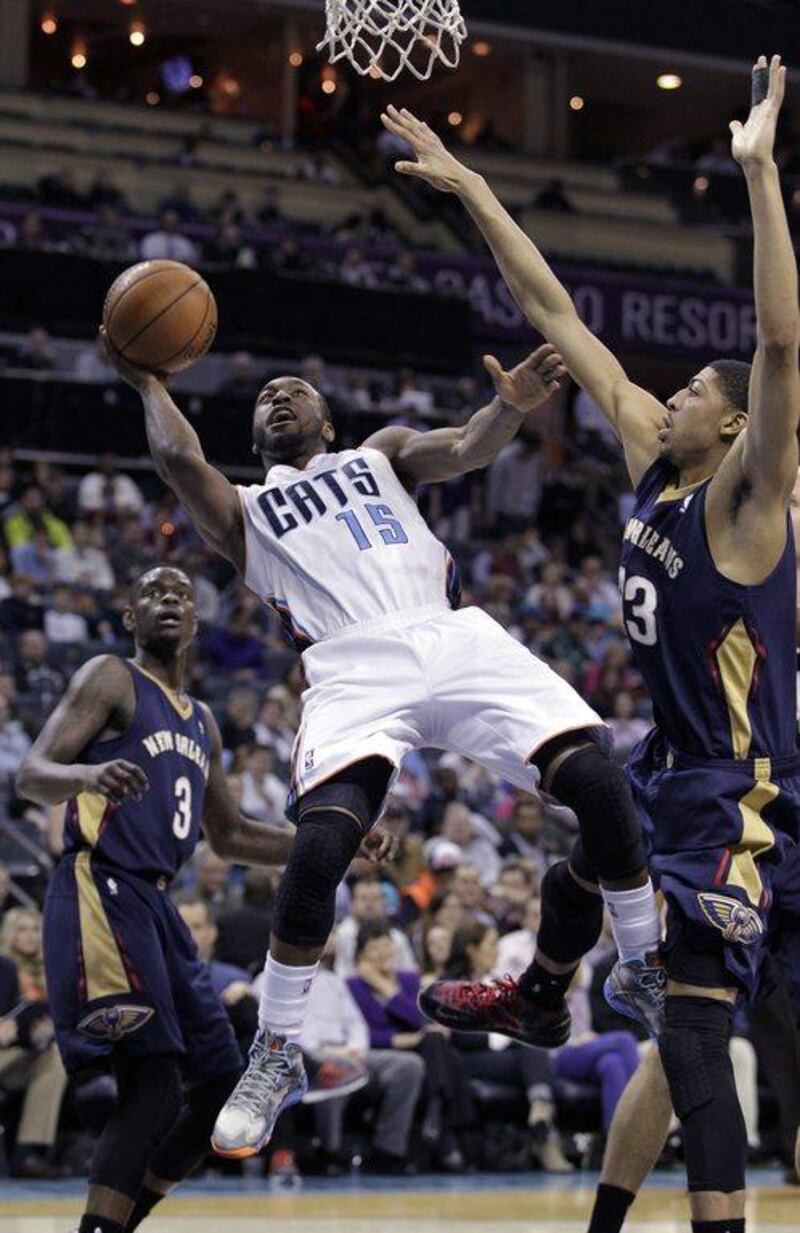 Charlotte Bobcats' Kemba Walker, left, gets his shot off despite being fouled by New Orleans Pelicans' Anthony Davis during the second half of an NBA basketball game in Charlotte, N.C. on Friday, February. 21, 2014. The Bobcats won 90-87. AP Photo/Bob Leverone