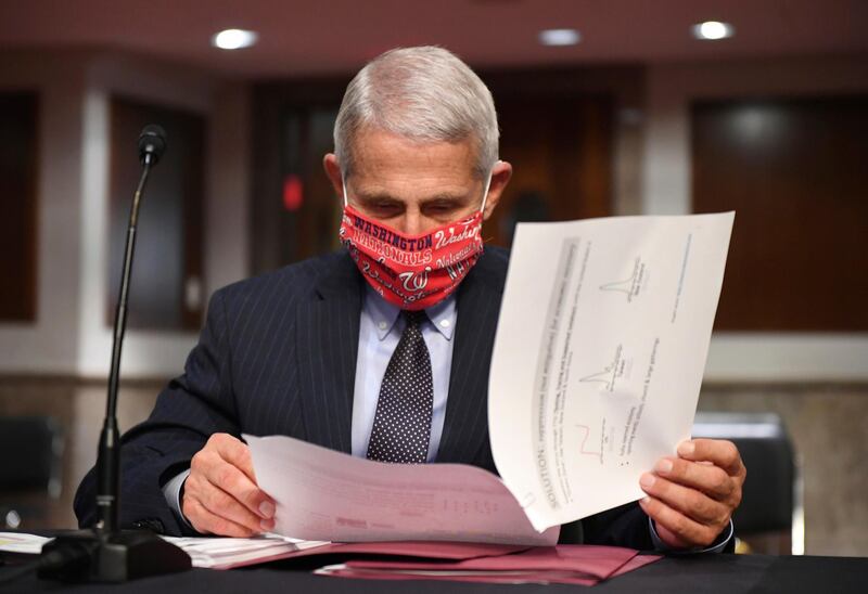 FILE - In this Tuesday, June 30, 2020 file photo, Dr. Anthony Fauci, director of the National Institute for Allergy and Infectious Diseases, prepares to testify before a Senate Health, Education, Labor and Pensions Committee hearing on Capitol Hill in Washington. On Friday, July 10, 2020, The Associated Press reported on stories circulating online incorrectly asserting that Fauci is married to Ghislaine Maxwellâ€™s sister. Fauci is married to Christine Grady, chief of the bioethics department at the National Institutes of Health Clinical Center. (Kevin Dietsch/Pool via AP)