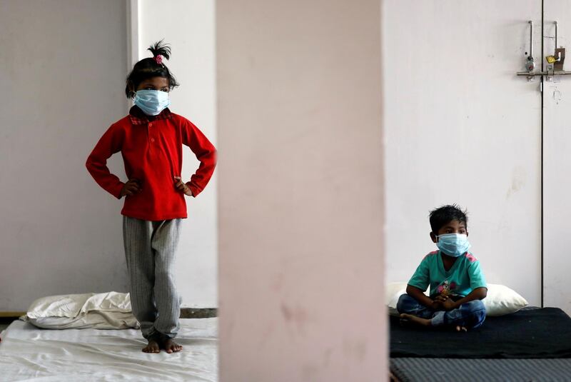 Children of migrant workers wear protective masks inside a sports complex turned into a shelter, during a 21-day nationwide lockdown to slow the spread of the coronavirus disease (COVID-19), in New Delhi, India. REUTERS