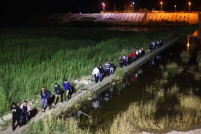 Immigrants walk from Mexico into the US on their way to await processing by the US Border Patrol on May 23, 2022 in Yuma, Arizona. Getty Images / AFP
