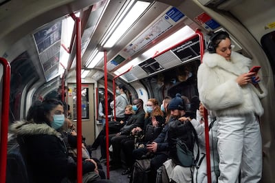 Commuters, some wearing face coverings to help prevent the spread of coronavirus, travel on the London Underground. AFP