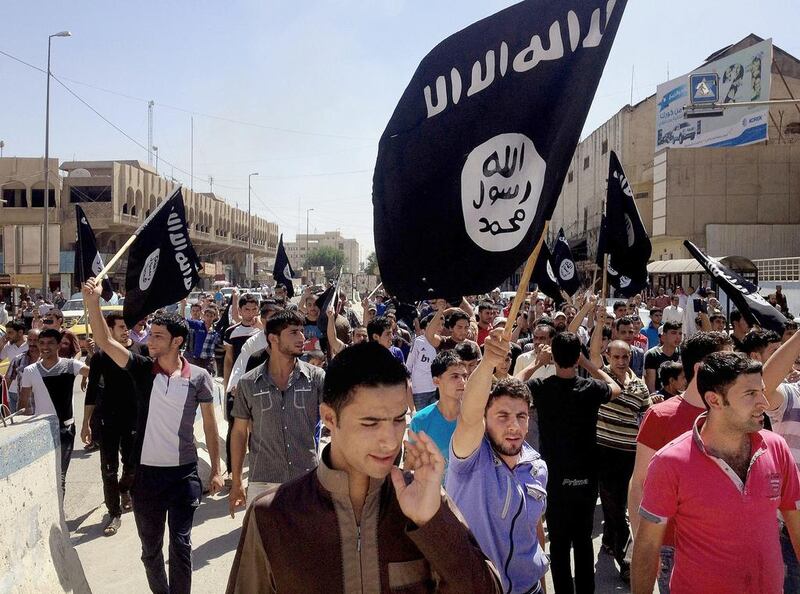 Demonstrators chant pro-ISIL slogans as they carry the group's flags. Seeking the assistance of the Syrian regime in fighting ISIL is dangerous and morally indefensible, says Faisal Al Yafai (AP Photo, File)