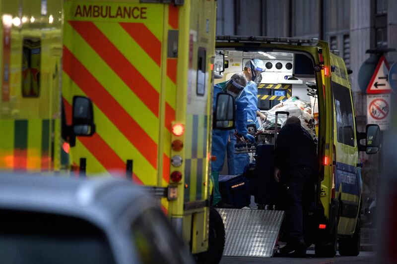 LONDON, ENGLAND - JANUARY 05: A medical team wear full protective PPE as they assist a patient in an ambulance outside the Royal London Hospital, on January 05, 2021 in London, England. The British Prime Minister made a national television address on Monday evening announcing England is to enter its third lockdown of the covid-19 pandemic.On Monday the UK recorded more than 50,000 new confirmed Covid cases for the seventh day in a row. (Photo by Leon Neal/Getty Images)