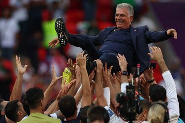 Iran's players celebrate their victory with Iran's Portuguese coach Carlos Queiroz during the Qatar 2022 World Cup Group B football match between Wales and Iran at the Ahmad Bin Ali Stadium in Al-Rayyan, west of Doha on November 25, 2022.  (Photo by Adrian DENNIS  /  AFP)