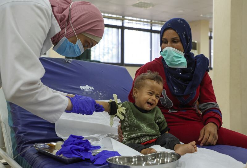 A health worker treats a child who is suspected of having cholera at a field hospital in Bebnine, Akkar district, northern Lebanon. All photos: Reuters