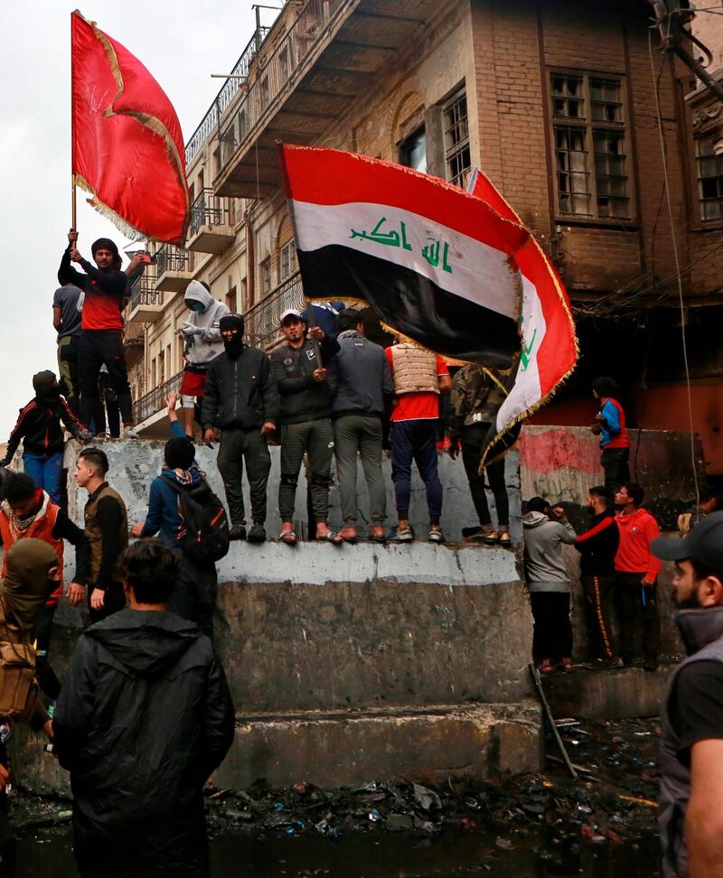 Anti-government protesters gather on barriers set up by security forces to close Rasheed Street during ongoing protests in Baghdad. AP Photo