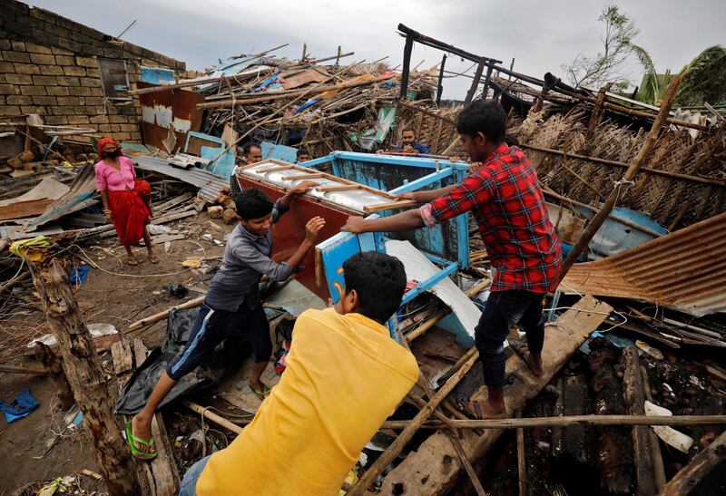 People salvage belongings from a damaged house in Navabandar village in the western state of Gujarat, India. Reuters