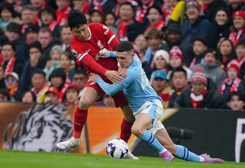 Liverpool's Wataru Endo and Manchester City's Phil Foden battle. PA 