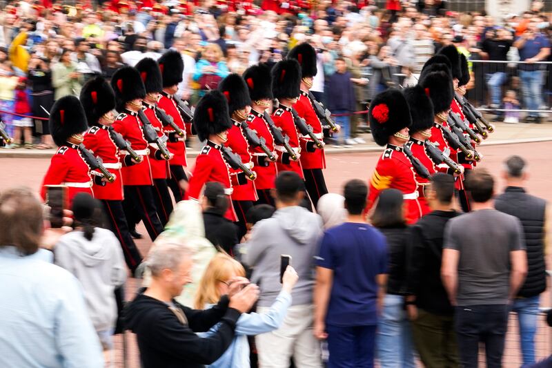 Soldiers from the Coldstream Guards march from their London barracks to the home of Queen Elizabeth II to mount the guard, as scores of spectators watch and take pictures. AP Photo