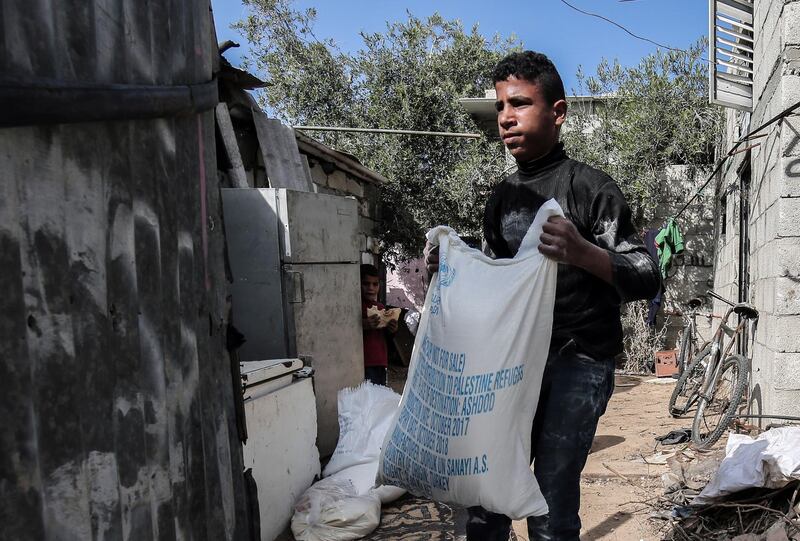 A Palestinian man delivers food aid provided by the UN agency for Palestinian refugees to a family in the Rafah refugee camp in the southern Gaza Strip on January 24, 2018.
The head of the United Nations agency for Palestinians said last week the US decision to freeze tens of millions of dollars in aid resulted from diplomatic disputes rather than the agency's performance. / AFP PHOTO / SAID KHATIB