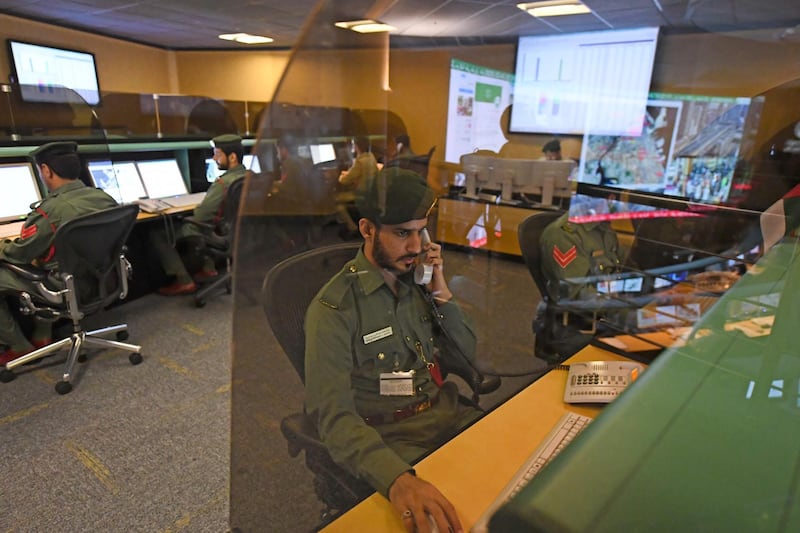 Police officers monitor the streets and receive calls from citizens at the Command and Control Center of Dubai Police in the Gulf emirate, on February 24, 2020. The novel coronavirus has given the Gulf emirate of Dubai an opportunity to showcase its technological and scientific clout as it seeks to shape its own model for approaching the pandemic. / AFP / KARIM SAHIB
