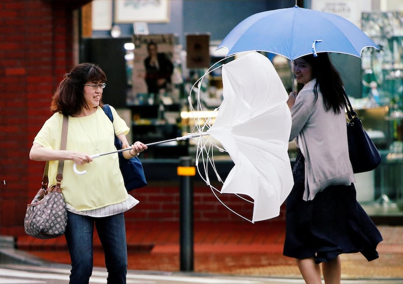 Passersby using umbrellas struggle against a heavy rain and wind as Typhoon Jongdari approaches Japan's mainland in Tokyo, Japan. REUTERS / Issei Kato