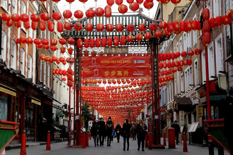 People walk beneath lanterns hung across the street to celebrate the Chinese Lunar New Year which marks the Year of the Ox, in the Chinatown district of central London. AP Photo