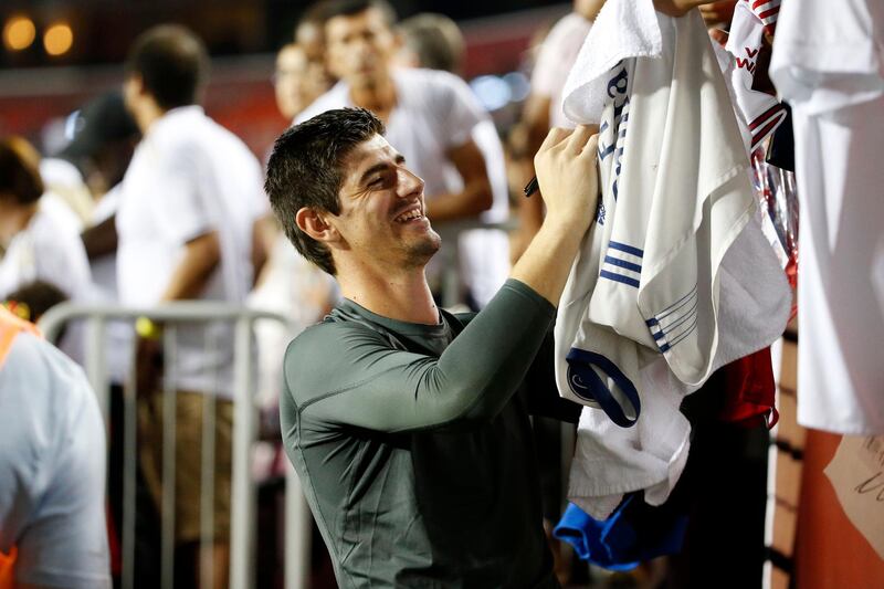 Real Madrid goalkeeper Thibaut Courtois signs autographs for fans in the stands. Reuters