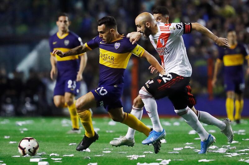 BUENOS AIRES, ARGENTINA - OCTOBER 22: Carlos Tevez of Boca Juniors and Javier Pinola of River Plate fight for the ball during the Semifinal second leg match between Boca Juniors and River Plate as part of Copa CONMEBOL Libertadores 2019 at Estadio Alberto J. Armando on October 22, 2019 in Buenos Aires, Argentina. (Photo by Marcos Brindicci/Getty Images)