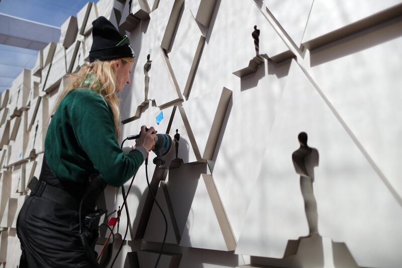 A worker sands an Oscars backdrop. Reuters