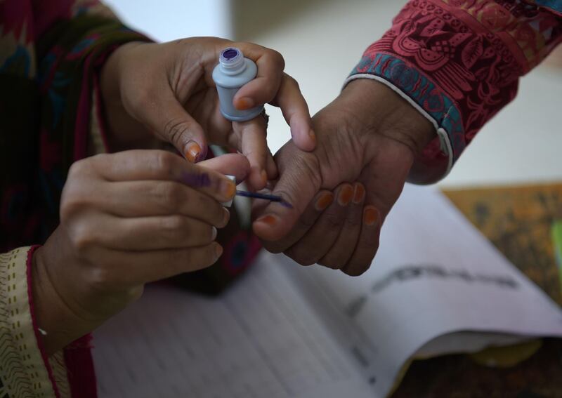 An election official marks a voters thumb before casting her vote in Islamabad. AFP