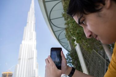 A customer takes a photo of the Burj Khalifa with his new iPhone 11 outside an Apple store during the launch of new iPhone 11 and iPhone 11 Pro at Dubai Mall in Dubai. EPA