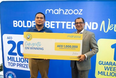 Farid Samji, chief executive of Ewings, hands over the Dh1 million cheque to Sherlon, a Filipino expat who scopped the prize in a Mahzooz raffle draw. Ruel Pableo for The National