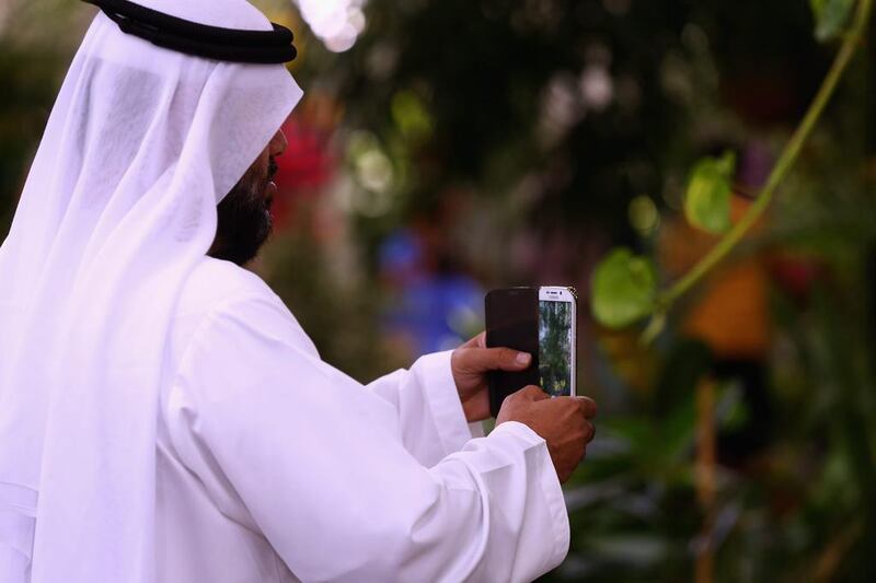 A man takes a picture during a visit to Dubai Butterfly Garden. Francois Nel / Getty Images
