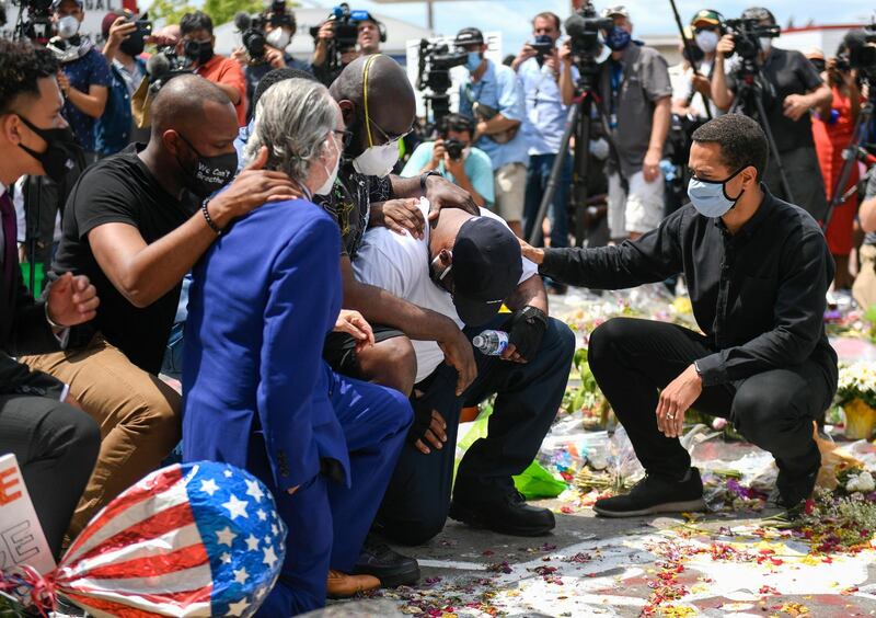 Terrence Floyd, wearing white T-shirt, kneels at a makeshift memorial for his brother, George Floyd, near the intersection of 38th and Chicago in front of the Cup Foods at the spot where he was arrested and died in police custody, in Minneapolis, Minnesota, US. EPA