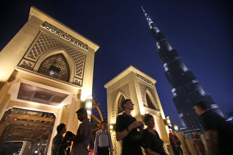 With the world tallest tower, Burj Khalifa, in background, tourists cross a bridge to Souk Al Bahar in Dubai. Overseas visitors spend far more in the city than in 11 global peers surveyed by Savills. Kamran Jebreili / AP